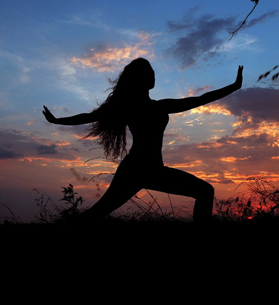 woman doing yoga at sunset