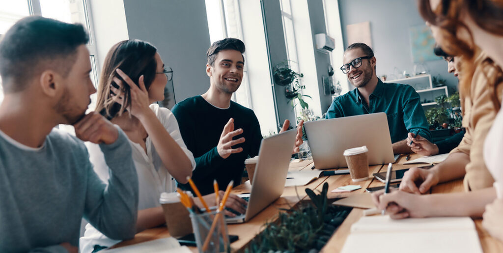 a few people around a table collaborating